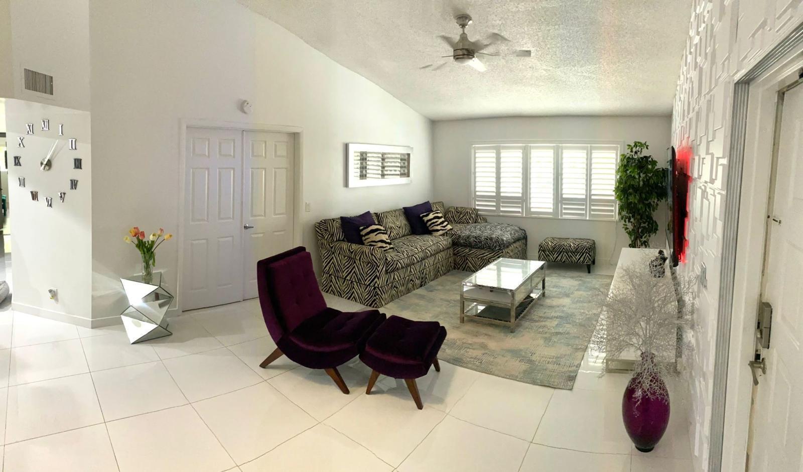 A living room features white tile floors, a zebra-print sectional, and a purple accent chair — 13770 Oneida Drive # B2, Delray Beach FL 33446, DELRAY BEACH, FL
