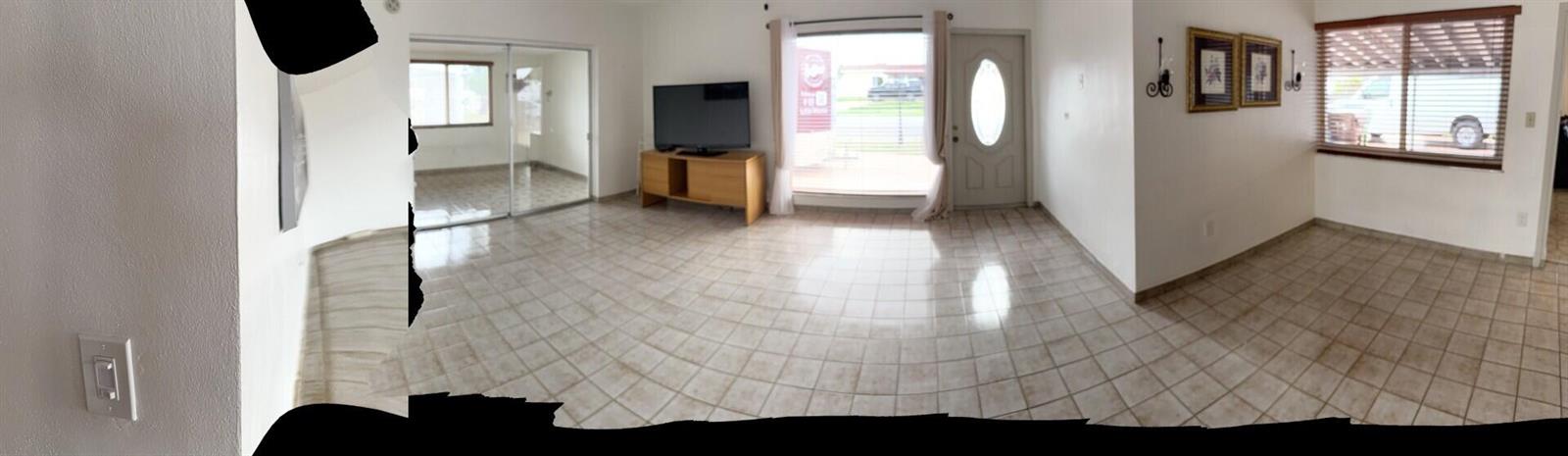 A panoramic view of a living room with tiled floors, a television, and a front door — 957 W 67th Street, Hialeah FL 33012, HIALEAH, FL