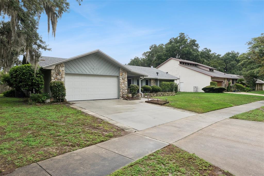 A single-story house with a stone facade, a two-car garage, and a concrete driveway — 4902 BRIAR OAKS CIRCLE, ORLANDO, FL