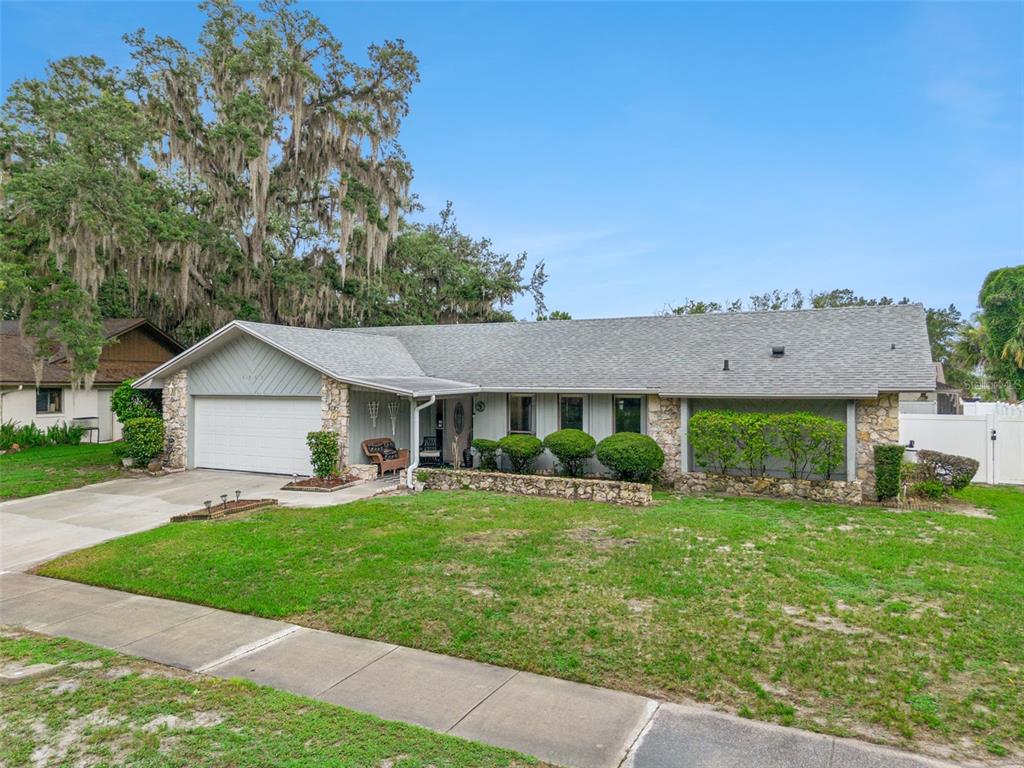 A single-story house with a stone facade, a two-car garage, and a large oak tree — 4902 BRIAR OAKS CIRCLE, ORLANDO, FL