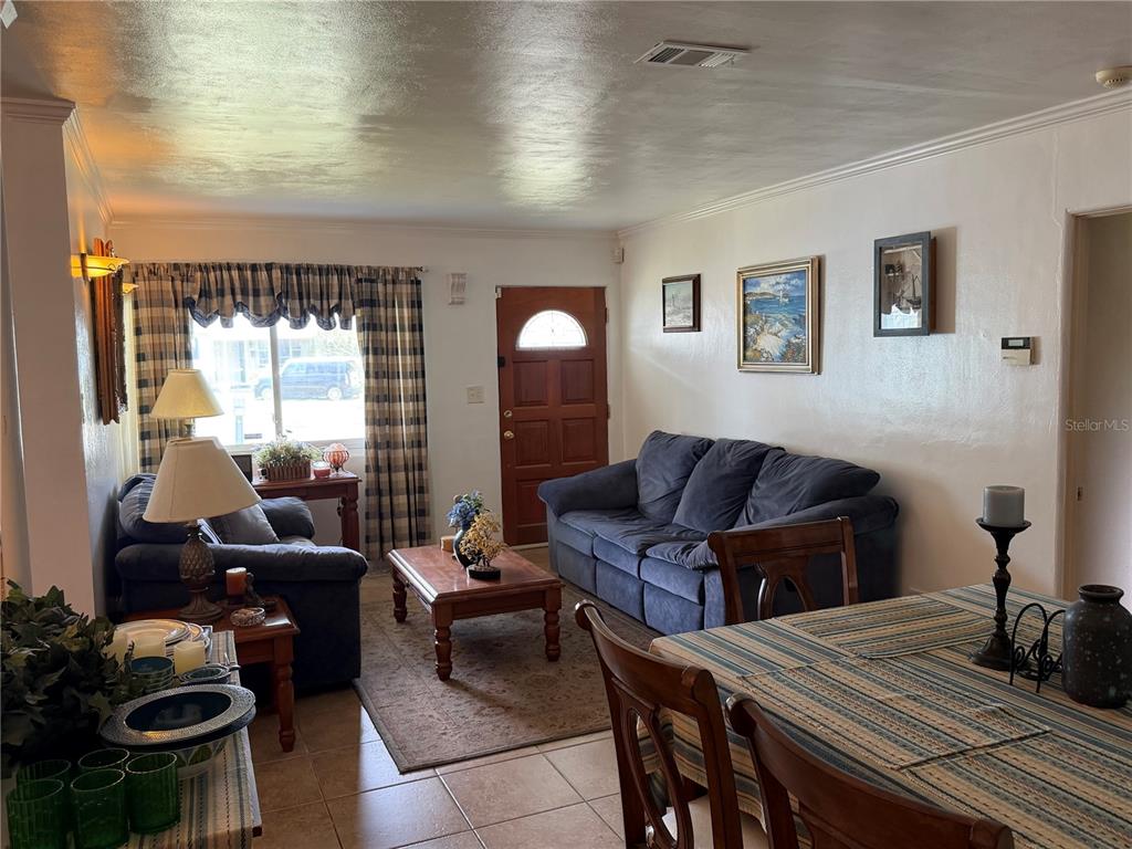 A living room features a blue sofa, a wooden coffee table, and a dining area — 616 DIAL DRIVE, ORLANDO, FL