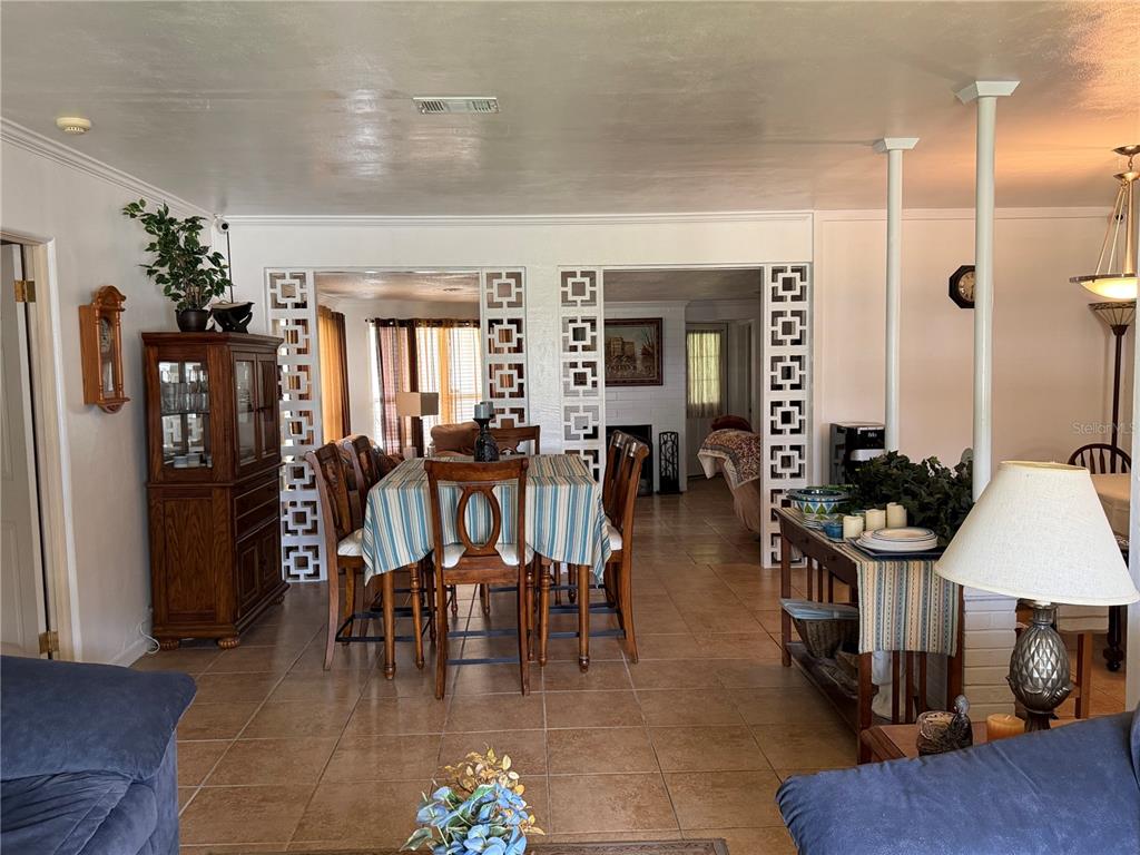 A dining area features a wooden table, chairs, and decorative breeze block room dividers — 616 DIAL DRIVE, ORLANDO, FL