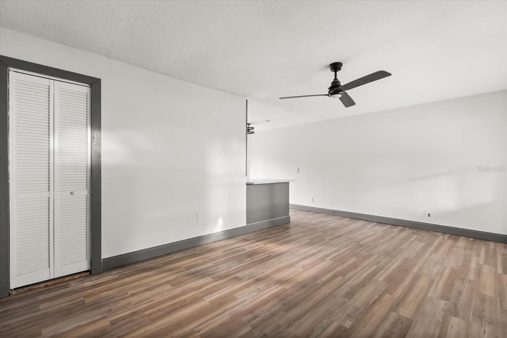 An empty room with wood-look flooring, a ceiling fan, and a gray-trimmed closet — 2507 NEWBERRY STREET, ORLANDO, FL