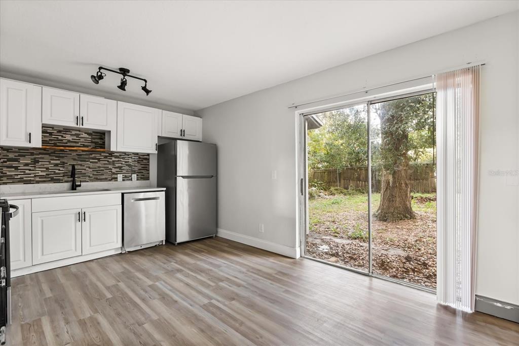 A kitchen with white cabinets, stainless steel appliances, and a sliding glass door to a yard — 2507 NEWBERRY STREET, ORLANDO, FL