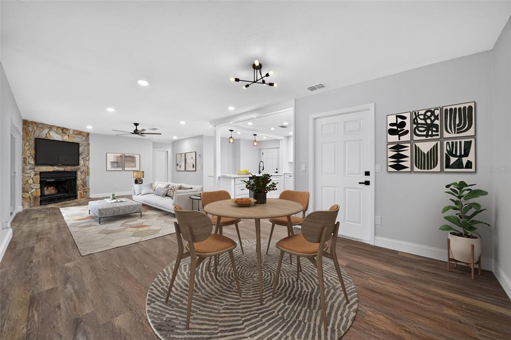 A dining area with a round table and chairs sits in front of a living room — 12100 CAROLINA WOODS LANE, ORLANDO, FL