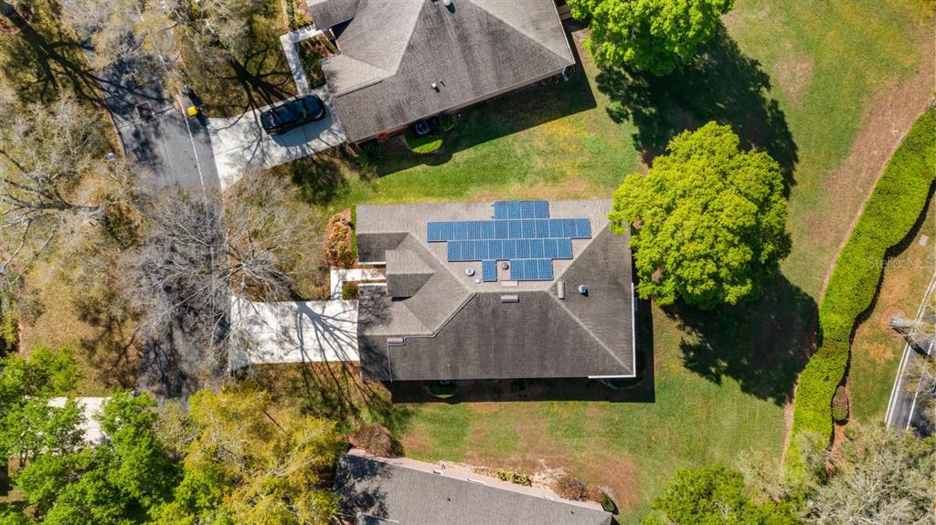 An aerial view shows a residential house with solar panels installed on the roof — 3734 HASTING LANE, CLERMONT, FL