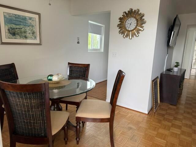 A dining area features a glass-topped table, wicker chairs, and a sunburst wall clock — 2840 Cynthia Lane # 203, FL 33461, FL