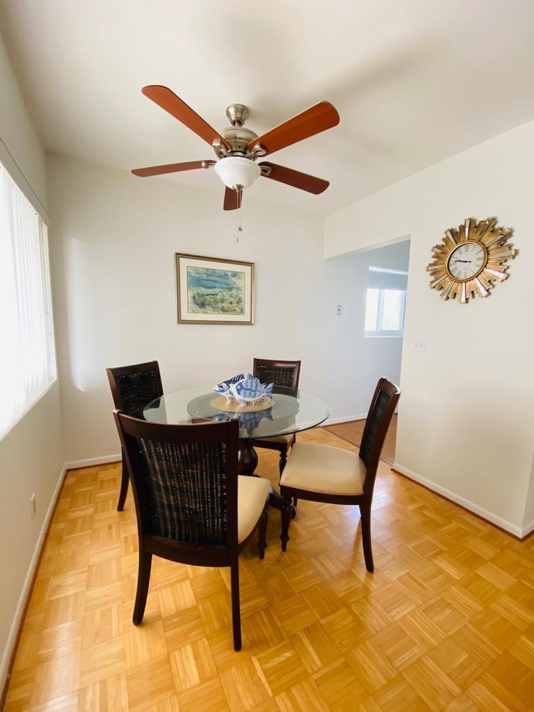 A dining area features a glass-topped table, four chairs, a ceiling fan, and parquet flooring — 2840 Cynthia Lane # 203, FL 33461, FL