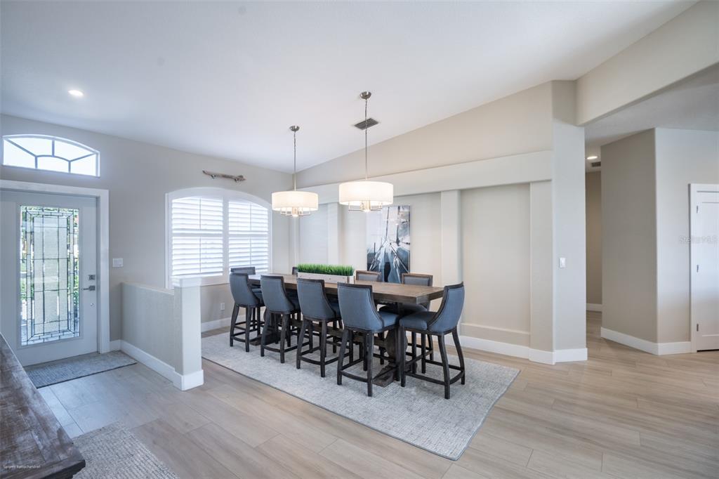 A dining room features a high-top table with six chairs, two pendant lights, and wood-look flooring — 6571 TALON BAY DRIVE, NORTH PORT, FL