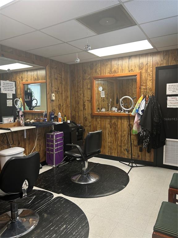 A hair salon room features wood-paneled walls, two styling chairs, mirrors, and a purple trolley — 1605 N TEMPLE AVENUE, STARKE, FL