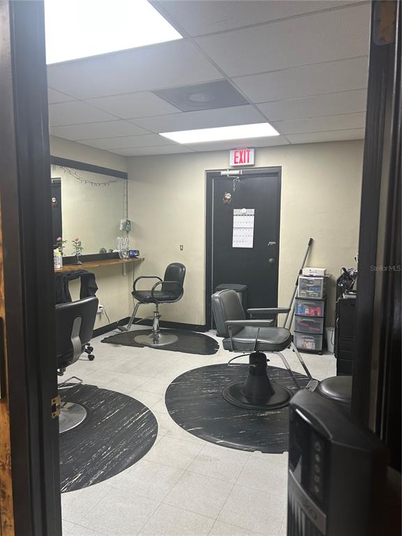 A hair salon room features two styling chairs, a mirror, and an exit door — 1605 N TEMPLE AVENUE, STARKE, FL