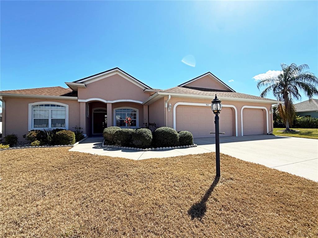 A single-story house with a tan exterior, two-car garage, and a dry, brown lawn — 9011 PROVINCE STREET, SARASOTA, FL