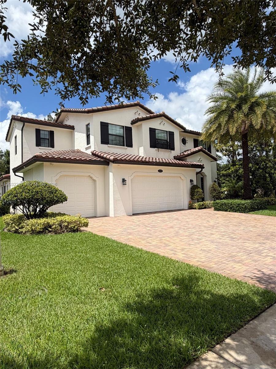 A two-story house with a tile roof, white stucco exterior, and a brick paver driveway — 10609 SW 55th St, Cooper City FL 33328, COOPER CITY, FL