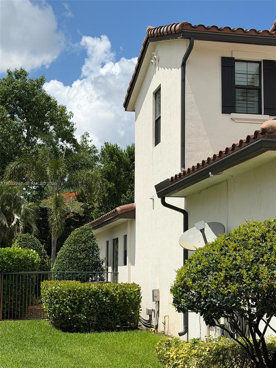A two-story stucco house exterior features a tile roof, dark shutters, and a satellite dish — 10609 SW 55th St, Cooper City FL 33328, COOPER CITY, FL