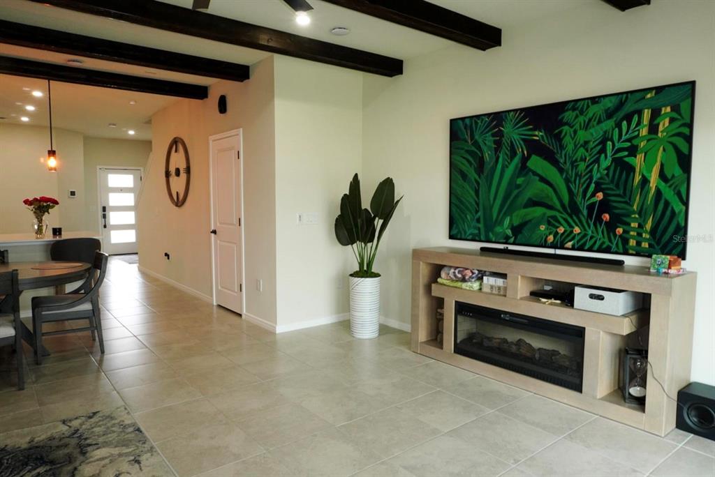 A living room features a large television, a media console with a fireplace, and tile flooring — 1730 DELIGHTFUL DRIVE, DAVENPORT, FL
