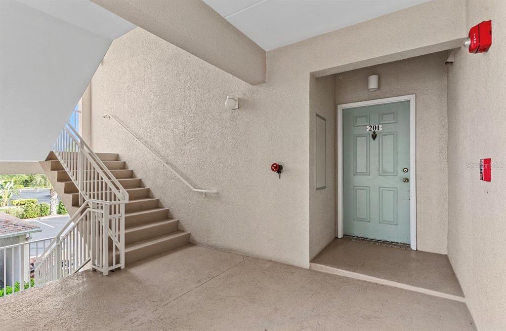 An exterior view shows a staircase leading to a landing with a light blue door — 2725 TERRA CEIA BAY BOULEVARD UNIT 201, PALMETTO, FL