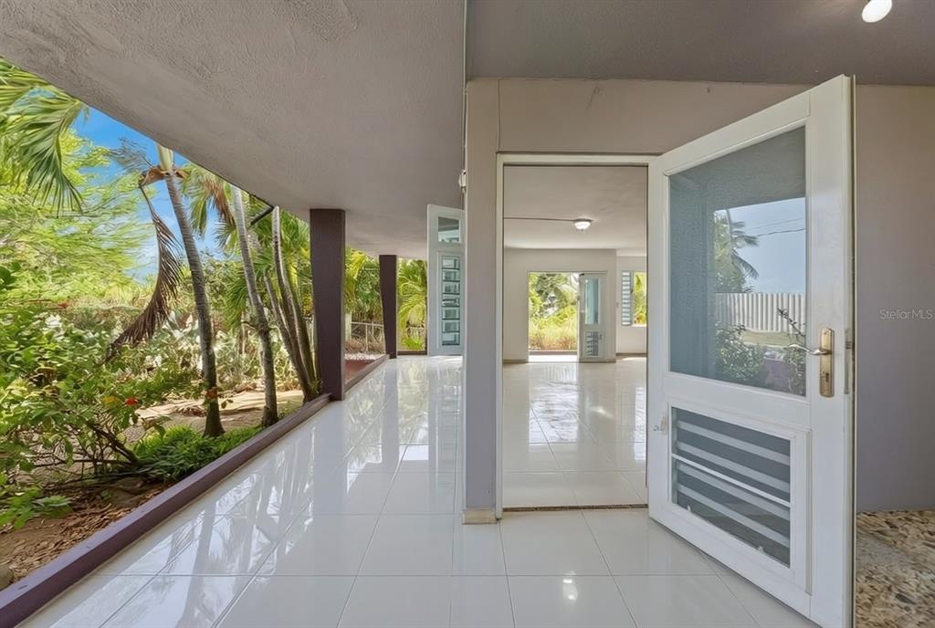 A corner lot house is surrounded by palm trees and a low concrete wall — 3-B CALLE KENNEDY, DORADO, PR