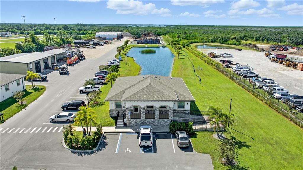 An aerial view shows a commercial building with a parking lot and a retention pond — 10305 US HIGHWAY 41 N, PALMETTO, FL