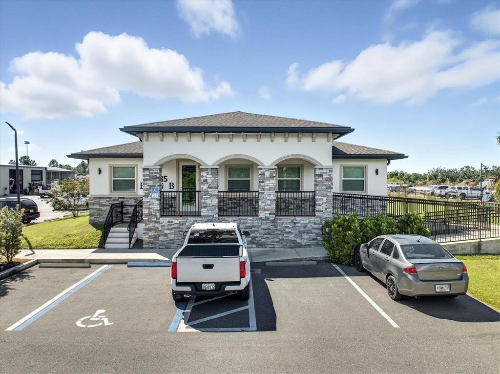A single-story commercial building with stone veneer, arched entryways, and a paved parking lot — 10305 US HIGHWAY 41 N, PALMETTO, FL