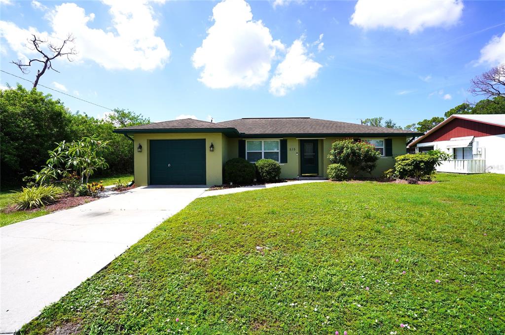 A single-story house with a green exterior, a one-car garage, and a grassy front yard — 515 MERIDAN AVENUE NW, PORT CHARLOTTE, FL