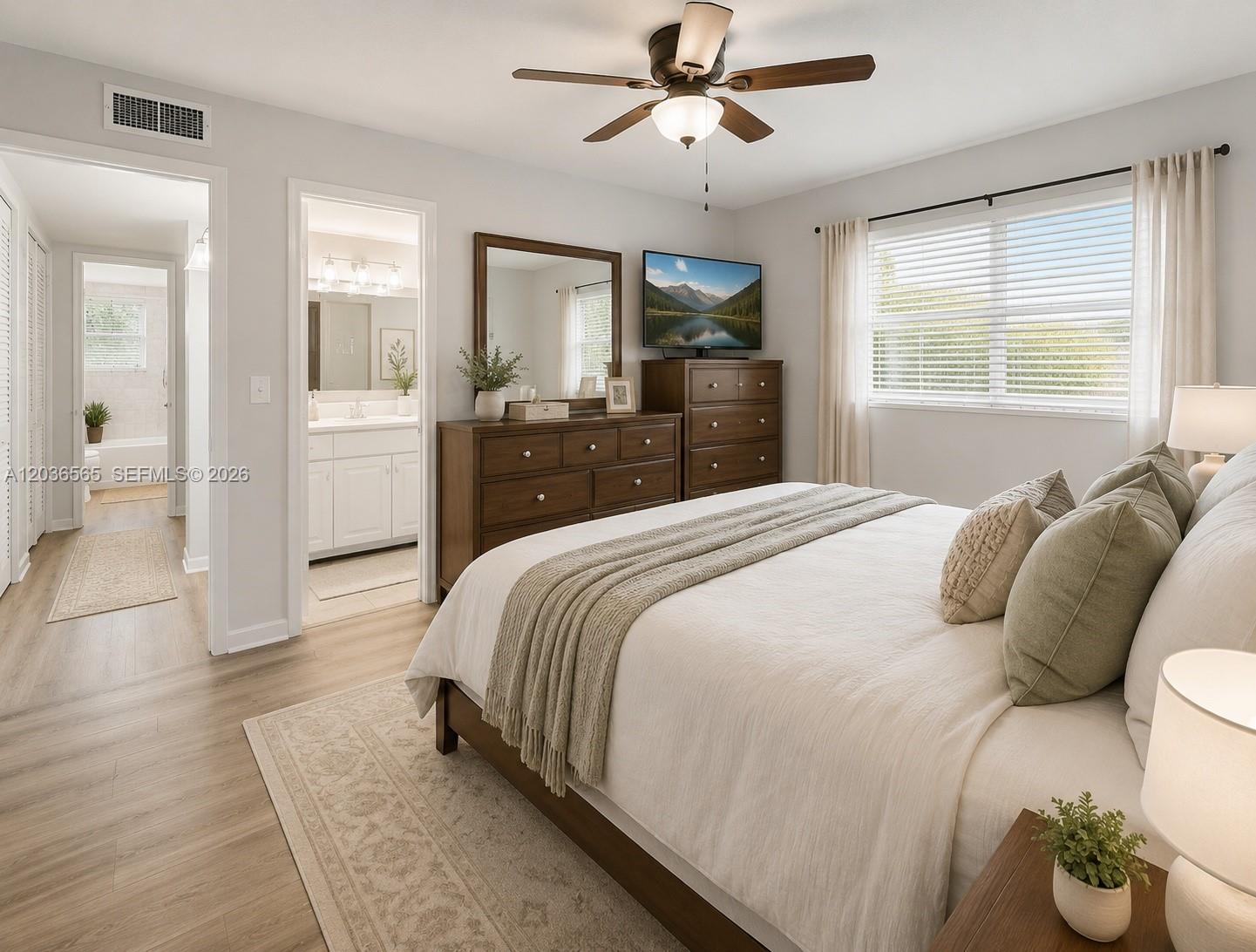 A bedroom features a bed, wooden dresser with a television, and an attached bathroom — 306 S Circle Dr S # 104, Boynton Beach FL 33435, BOYNTON BEACH, FL