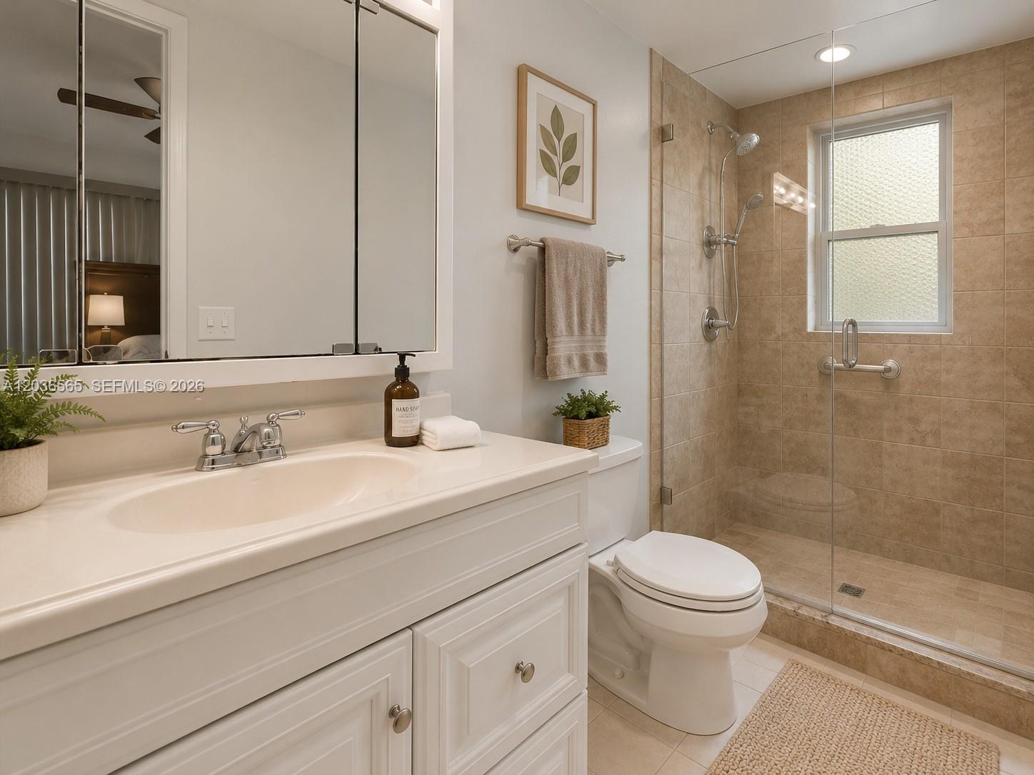 A bathroom features a white vanity, a toilet, and a glass-enclosed walk-in shower — 306 S Circle Dr S # 104, Boynton Beach FL 33435, BOYNTON BEACH, FL