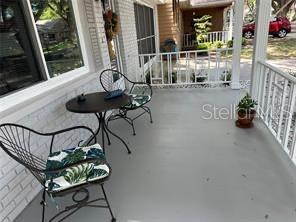 A covered porch features a small round table and two metal chairs with patterned cushions — 8552 SW 93RD PLACE UNIT C, OCALA, FL