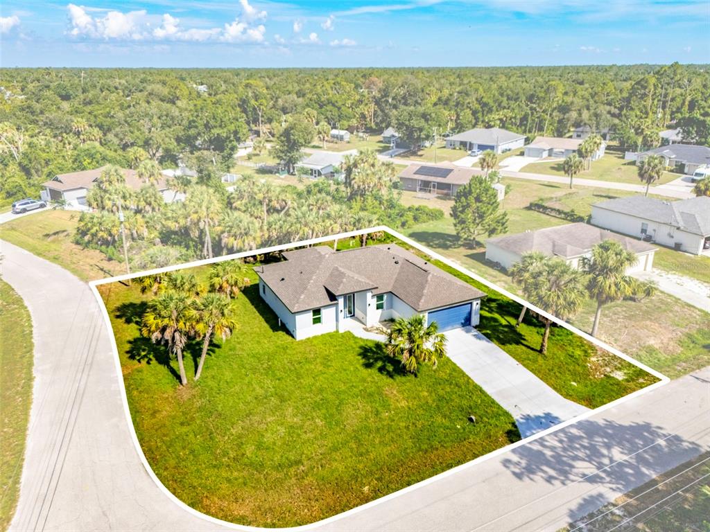 An aerial view shows a single-story house with a large lawn on a corner lot — 2830 BILLBERRY STREET, NORTH PORT, FL