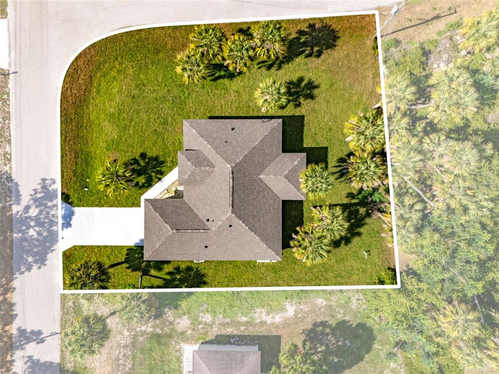 An aerial view shows a single-family house with a shingled roof on a corner lot — 2830 BILLBERRY STREET, NORTH PORT, FL