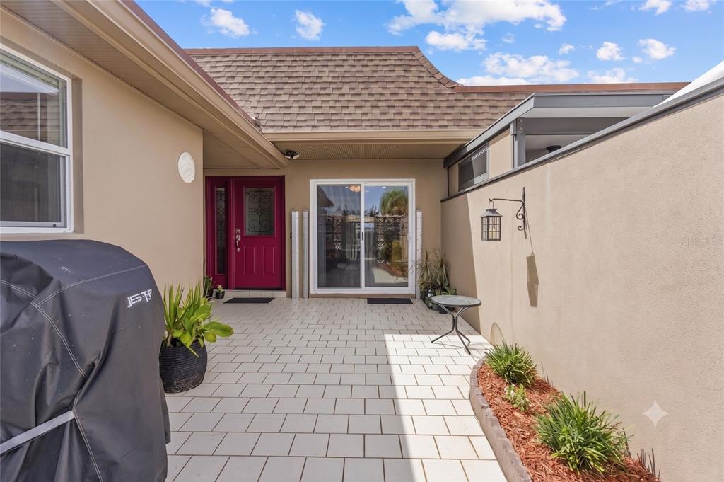 A paved courtyard features a red front door, sliding glass doors, and a covered grill — 531 BOCA CIEGA POINT BOULEVARD S UNIT 531, ST PETERSBURG, FL