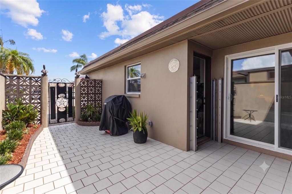 A tiled patio features a covered grill, a potted plant, and a sliding glass door — 531 BOCA CIEGA POINT BOULEVARD S UNIT 531, ST PETERSBURG, FL