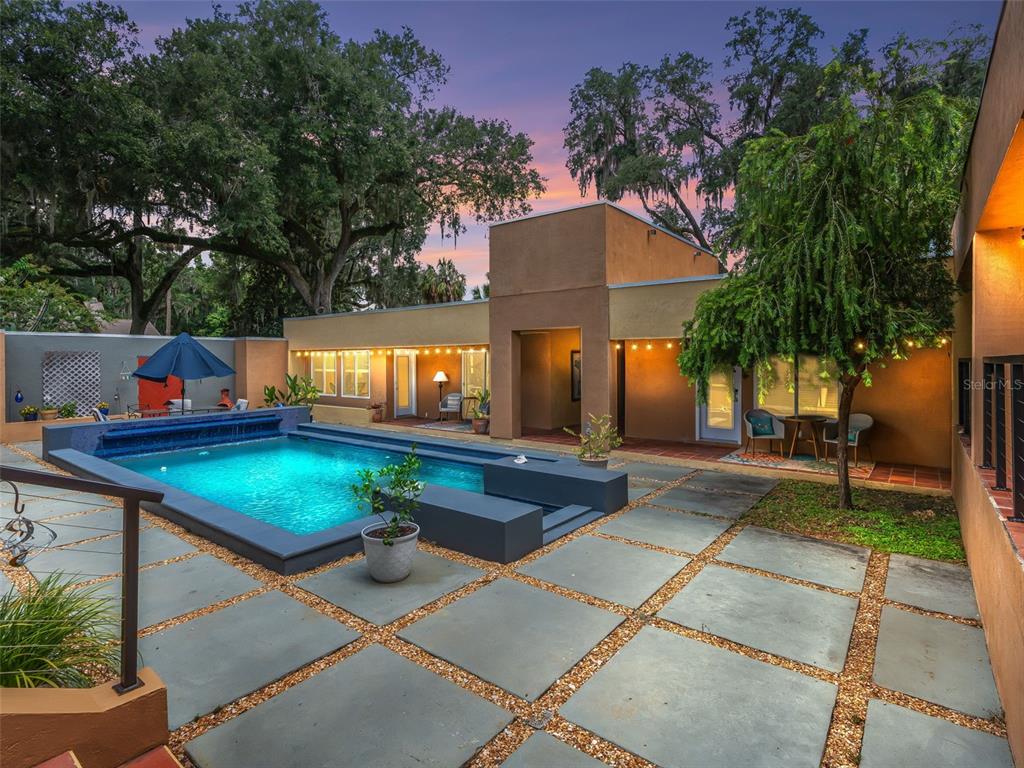 A modern house with a rectangular swimming pool and a paved patio at sunset — 2330 SW 37 STREET, OCALA, FL