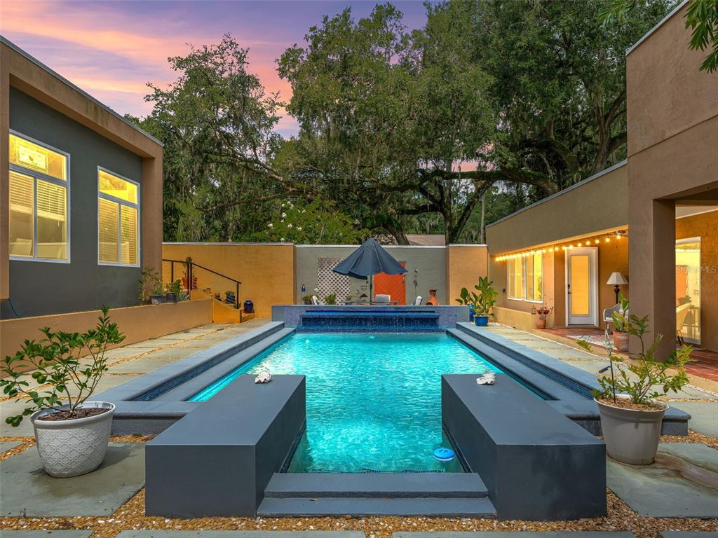 A rectangular swimming pool with a water feature sits in a courtyard between two buildings — 2330 SW 37 STREET, OCALA, FL
