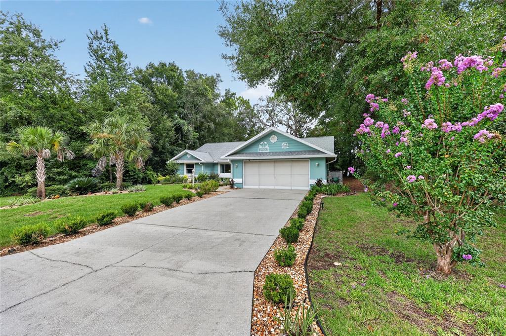 A teal, single-story house with a two-car garage and a long concrete driveway — 19683 SW 93RD LANE, DUNNELLON, FL