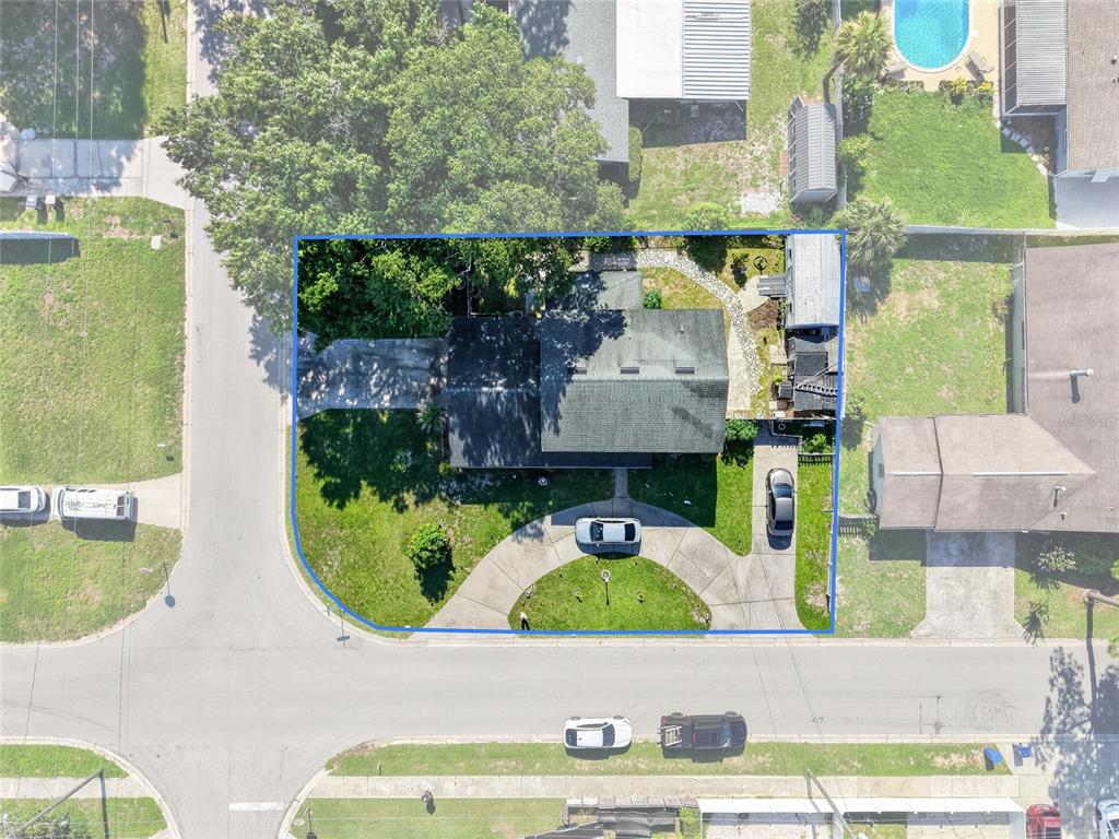 An aerial view shows a house with a driveway and yard outlined in blue — 1500 AVENUE G NE, WINTER HAVEN, FL