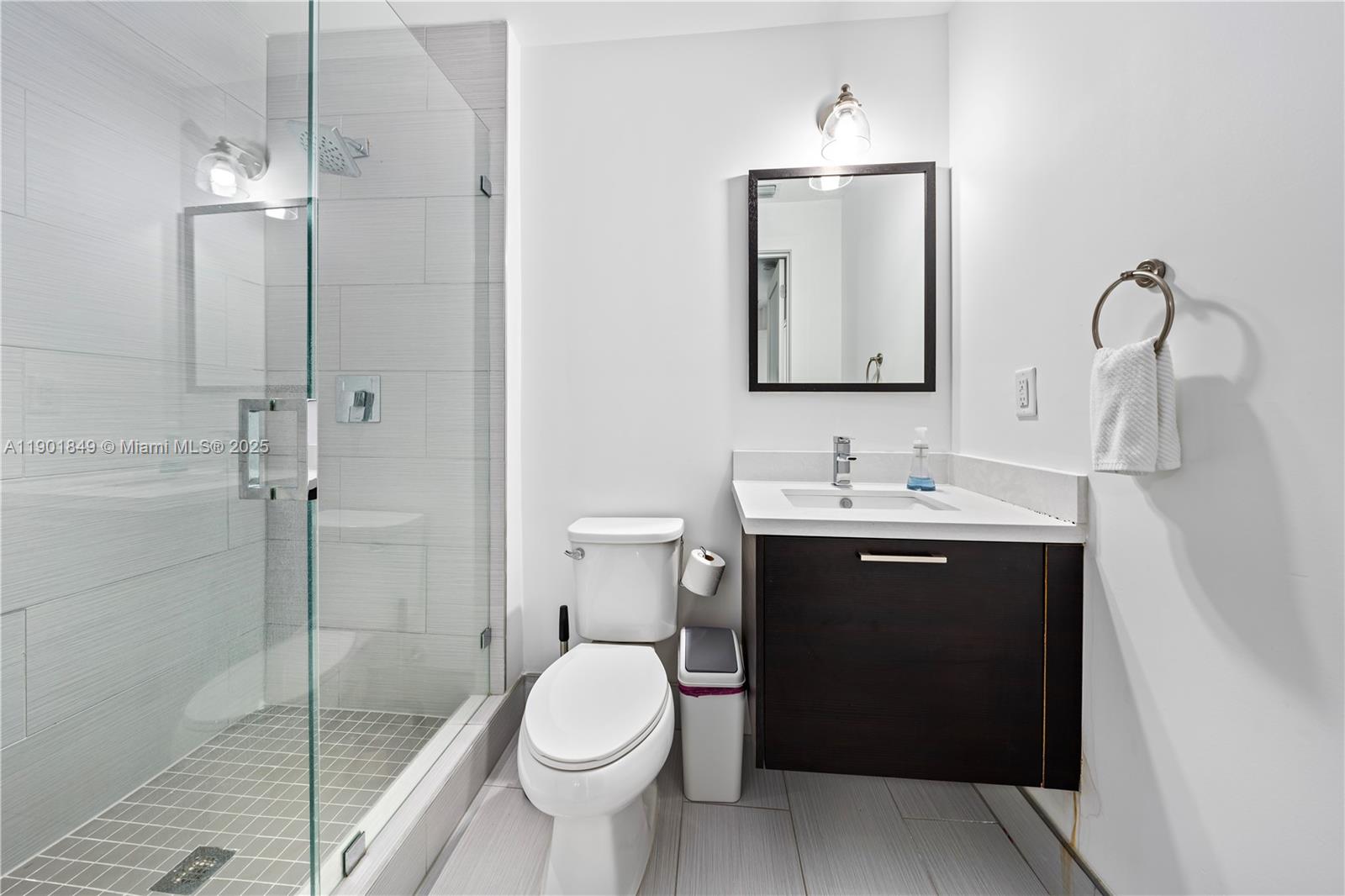 A modern bathroom features a glass-enclosed shower, a floating vanity, and a white toilet — 9153 NW 33rd St, Doral FL 33172, DORAL, FL