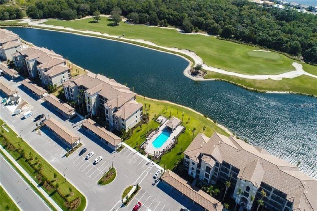 A stone monument sign for Lakewood National sits in front of a pond and golf course — 16706 VARDON TERRACE UNIT 208, LAKEWOOD RANCH, FL