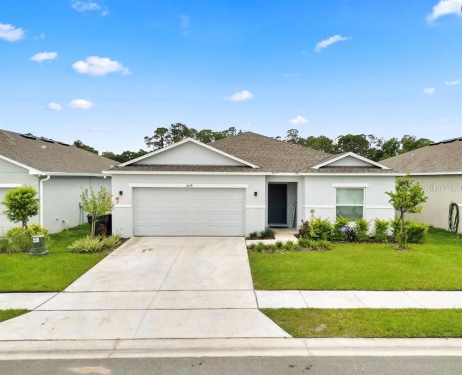A single-story house with a light gray exterior, a two-car garage, and a front lawn — 2039 ROSEWOOD CIRCLE, LAKELAND, FL