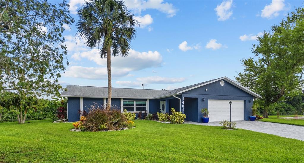 A blue single-story house with a two-car garage and a palm tree in the yard — 1401 GEORGETOWNE DRIVE, SARASOTA, FL