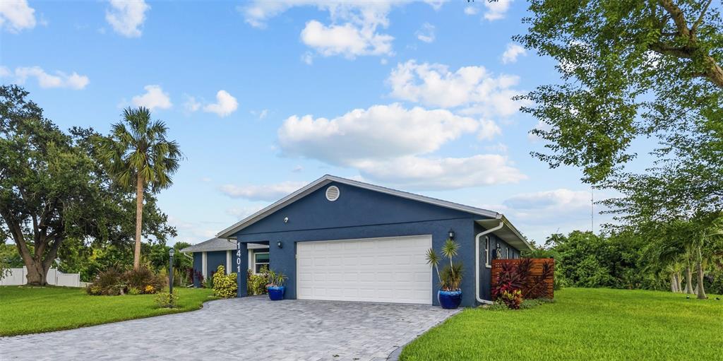 A blue house with a white garage door and a paved driveway sits on grass — 1401 GEORGETOWNE DRIVE, SARASOTA, FL