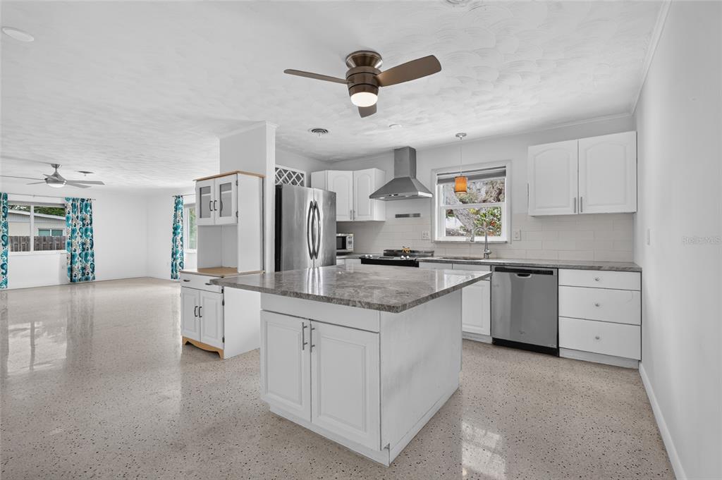 A kitchen with white cabinets, a gray island, stainless steel appliances, and terrazzo flooring — 2709 MARLETTE STREET, SARASOTA, FL
