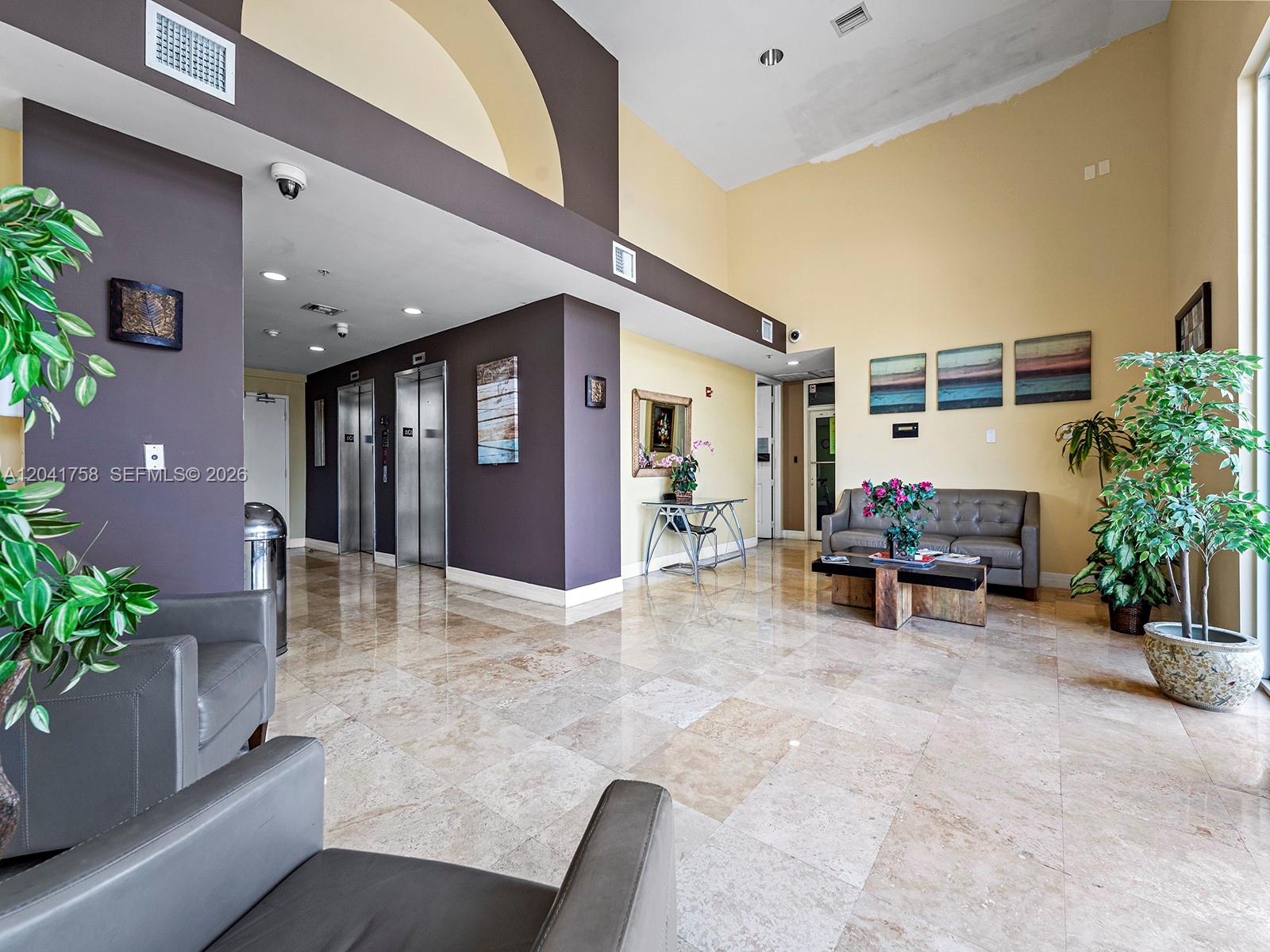 A lobby features a marble floor, two elevators, a gray sofa, and high ceilings — 215 SW 42nd Ave # 810, Miami FL 33134, MIAMI, FL