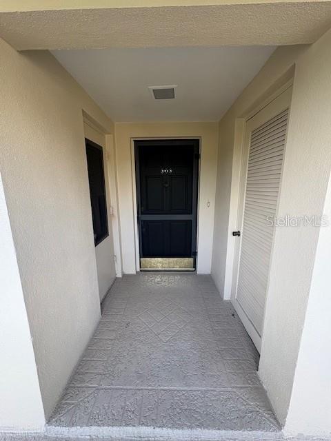 A covered entryway features a dark front door with a brass kickplate and tiled flooring — 147 BLUFF VIEW DRIVE UNIT 303, BELLEAIR BLUFFS, FL