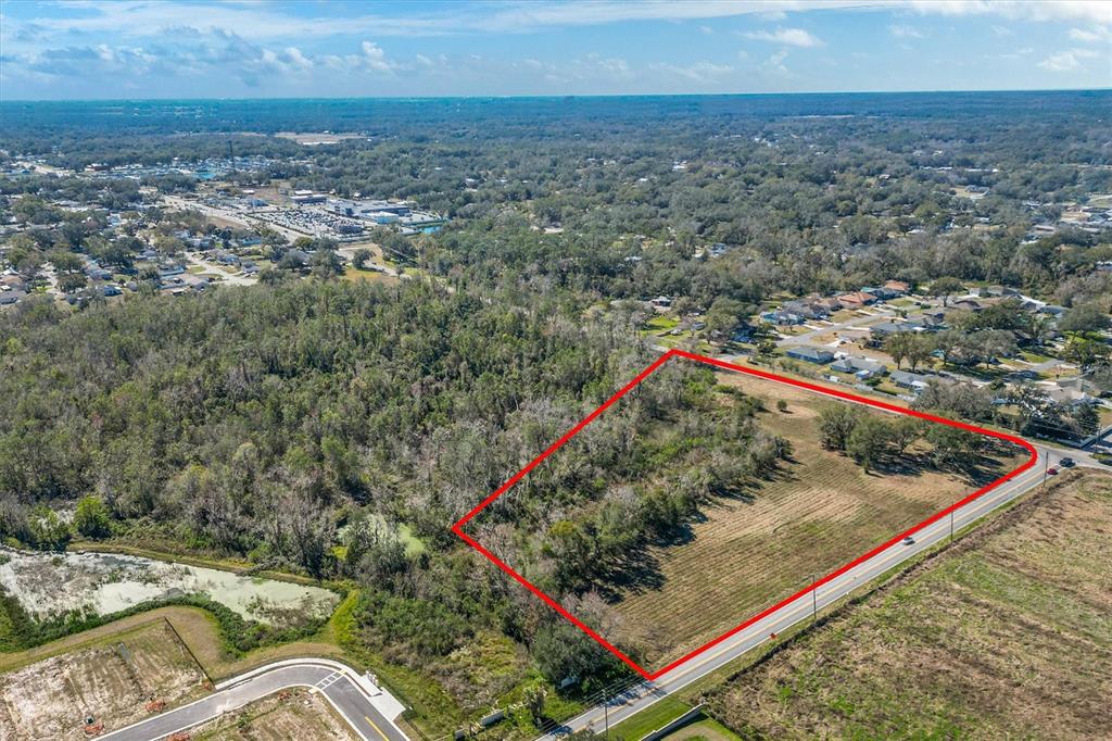 An aerial view shows a rectangular plot of land outlined in red beside a road — 7835 KATHLEEN ROAD, LAKELAND, FL