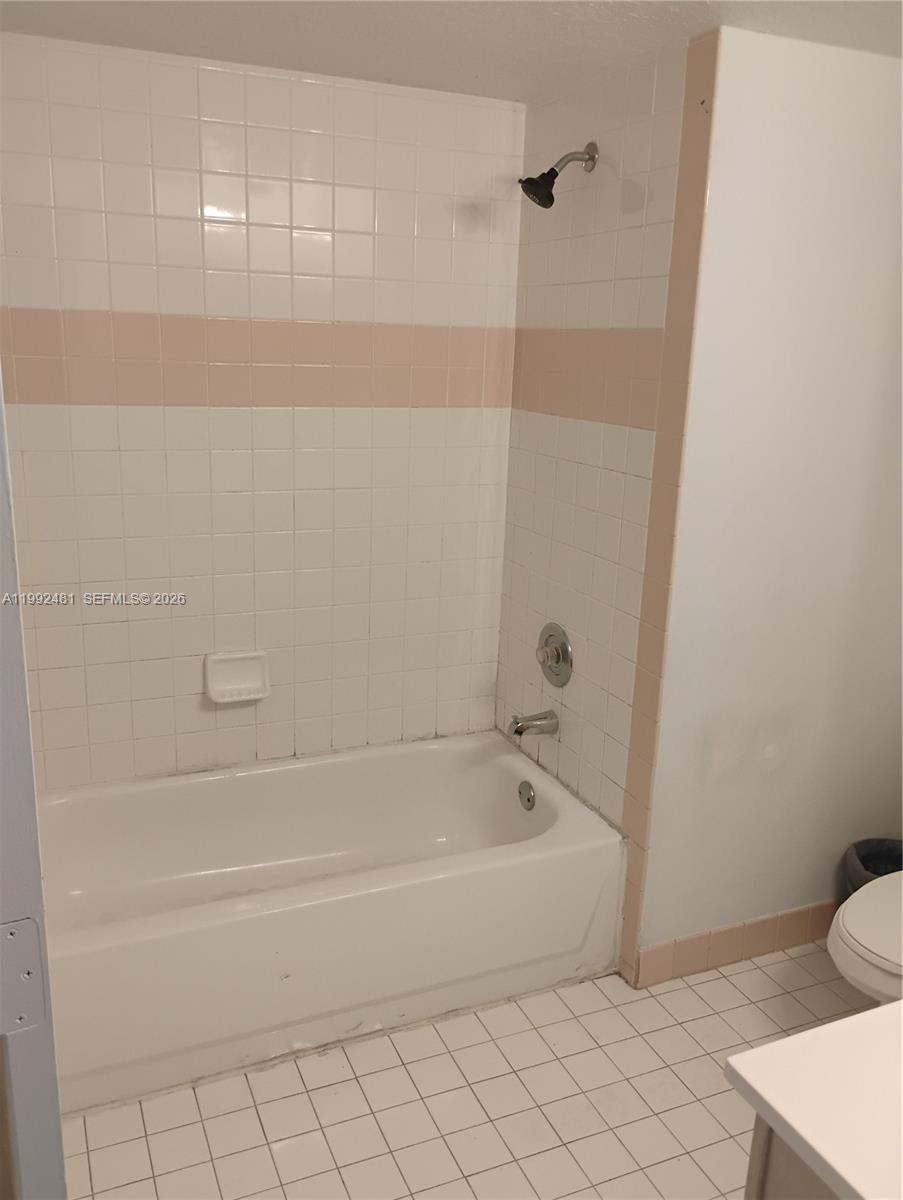 A bathroom features a white bathtub with a shower head and tiled walls — 3748 NW 91st Ln # 3748, Sunrise FL 33351, SUNRISE, FL