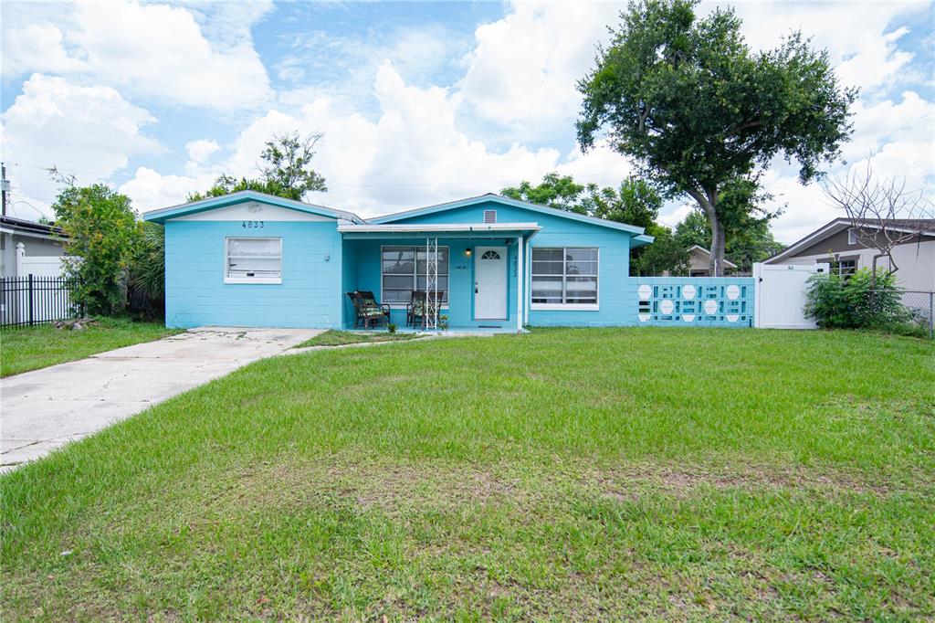 A single-story blue house with a concrete driveway and a front porch — 4833 CROW STREET, ORLANDO, FL
