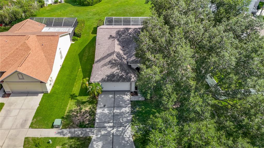 An aerial view shows two suburban houses with driveways, lawns, and screened-in back patios — 9718 PLEASANT RUN WAY, TAMPA, FL