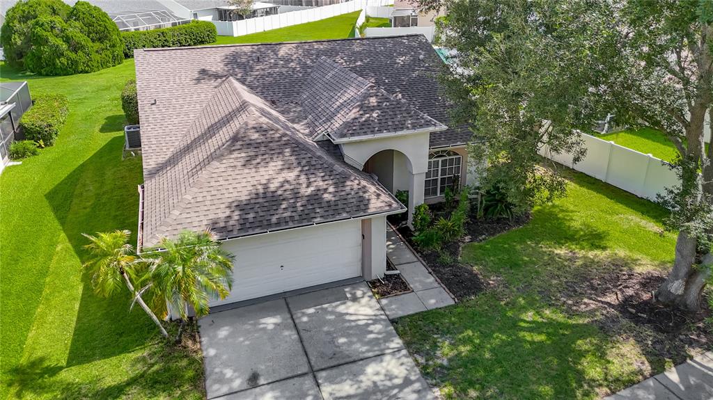 An aerial view shows a single-story house with a shingled roof and a two-car garage — 9718 PLEASANT RUN WAY, TAMPA, FL