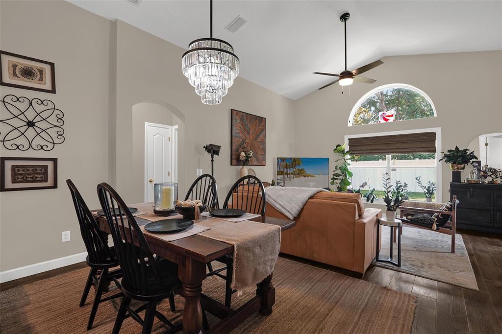 A dining area with a wooden table and black chairs sits before a living room — 1393 WAUKON CIRCLE, CASSELBERRY, FL