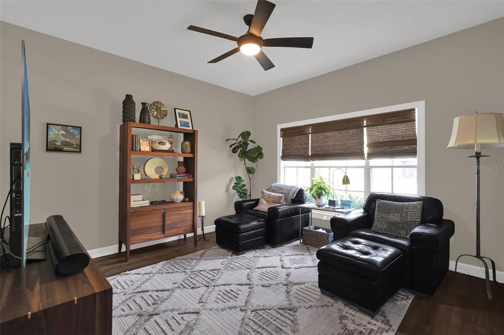 A living room features two leather armchairs with ottomans, a wooden bookshelf, and a ceiling fan — 1393 WAUKON CIRCLE, CASSELBERRY, FL